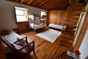 a room with two bunk beds and a ladder at Caldeira Guesthouse in Fajã da Caldeira de Santo Cristo