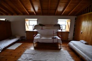 a room with two bunk beds and two windows at Caldeira Guesthouse in Fajã da Caldeira de Santo Cristo