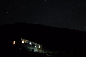 a night scene of a building with a sky background at Caldeira Guesthouse in Fajã da Caldeira de Santo Cristo