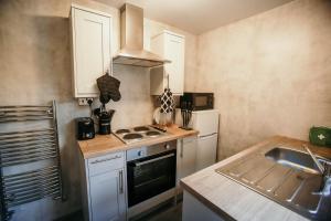 a small kitchen with a stove and a sink at PARKER St by Prestige Properties SA in Barrow in Furness
