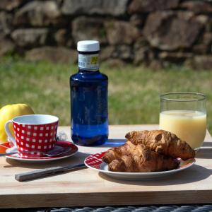 a table with a plate of food and a bottle of orange juice at Casal Rivas in Muxia