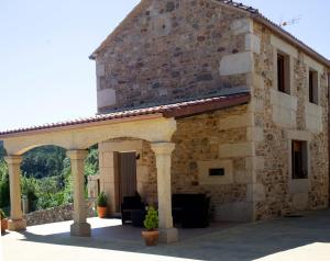 an external view of a stone building with a patio at Casal Rivas in Muxia
