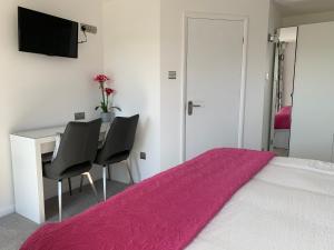 a bedroom with a bed and a desk with two chairs at The Bungalows Guesthouse in Threlkeld