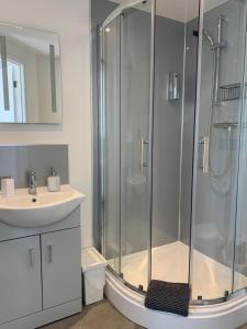a bathroom with a shower and a sink at The Bungalows Guesthouse in Threlkeld +9 photos