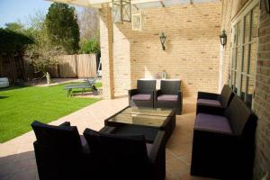 une terrasse avec des canapés, une table et des chaises dans l'établissement Spaanse Bungalow nabij Amsterdam with Sauna and steam sauna, à Vijfhuizen