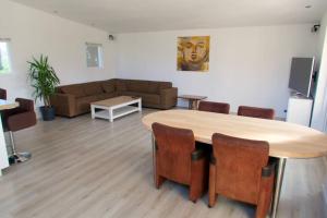 a living room with a table and a couch at Bungalow between Amsterdam and Haarlem with sauna in Vijfhuizen +16 photos