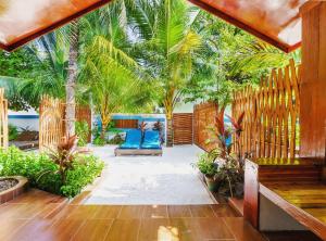 a patio with blue chairs and palm trees at Beach Villa Ukulhas in Ukulhas
