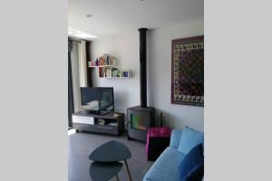 a living room with a blue couch and a tv at Casa Moderna en Fanzara, Castellón, pueblo MIAU in Fanzara