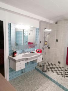 a bathroom with a sink and a shower at Chambre d'hôtes Les Myriades D'Or in Regny