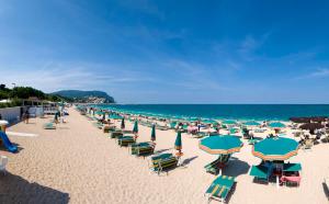 a beach with chairs and umbrellas and the ocean at Daniela Camere in Sirolo