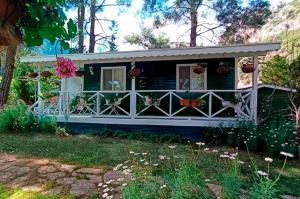 a house with a porch with flowers in it at Lukkies Lodge Cirali in Cıralı