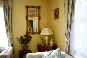 a living room with a white couch and a mirror at Sleeps14 Seaside Luxury House on the Suffolk Coast in Saxmundham