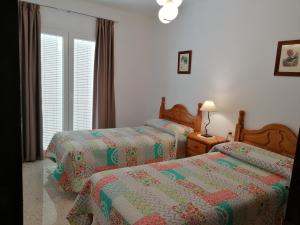 a bedroom with two beds and a window at Apartamento rural Alborada in Cómpeta