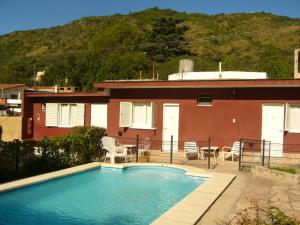 a swimming pool in front of a house at Amanitas Posada in Villa Carlos Paz