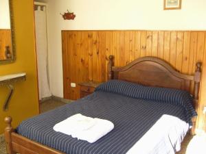a bed with two towels sitting on top of it at Amanitas Posada in Villa Carlos Paz