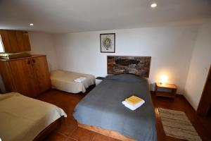 a bedroom with two beds in a room with at Caldeira Guesthouse in Fajã da Caldeira de Santo Cristo