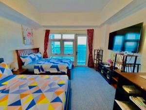 a bedroom with two beds and a view of the ocean at Grand Condo-Hotel with Breathtaking Seaside Views in Lapu-Lapu, Cebu in Mactan