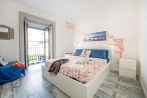 a white bedroom with a bed and a window at Il Ciottolo Sorrento in Sorrento