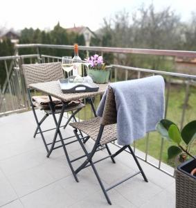 a table and two chairs on a balcony with a table and a towel at Rozmaring Vendégház in Orosháza