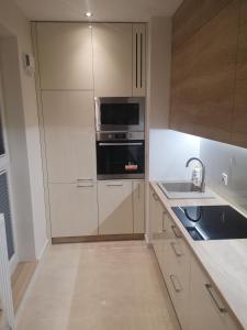 a kitchen with a refrigerator and a sink at Gwiazda Bemowa in Warsaw