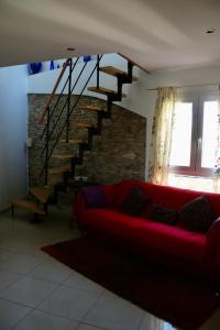 a living room with a red couch and a staircase at Apartamentos Fornells in Castelló d'Empúries