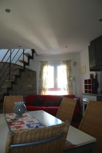 a living room with a red couch and a staircase at Apartamentos Fornells in Castelló d'Empúries