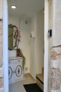 bagno con tavolo da trucco e specchio a parete. di Apartamentos Fornells a Castelló d'Empúries