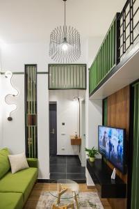 Una sala de estar con un sofá verde y un televisor. en LIT Apartments, en Tirana