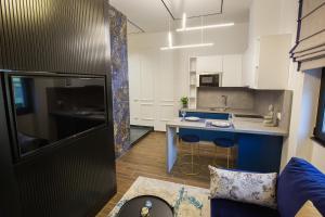 una pequeña cocina con una isla azul en una habitación en LIT Apartments, en Tirana