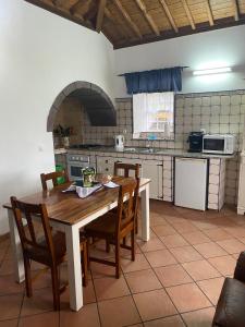 a kitchen with a wooden table and chairs in a room at Casa da Avó - Turismo Rural in Santo Espírito
