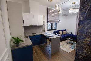 cocina y sala de estar con armarios azules y sofá azul en LIT Apartments, en Tirana 49 fotos más