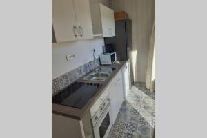 een keuken met een wastafel en een koelkast bij Bel appartement dans le Golfe de Saint Tropez in Les Issambres