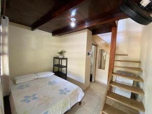 a small bedroom with a bed and a staircase at Suite rustica in Paraty