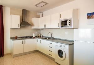 a kitchen with white cabinets and a washer and dryer at Vivienda rural Alborada in Cómpeta +23 photos