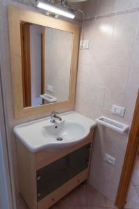uma casa de banho com um lavatório e um espelho em Appartamento il Bucaniere a Marina di Cecina em Marina di Cecina