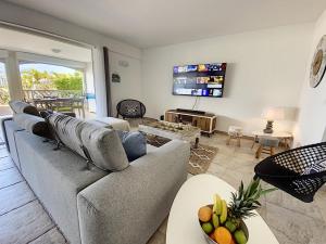 sala de estar con sofá y TV en Princess Coco, Beachfront, Pool, Orient Bay, ultra fast Wifi, en Orient Bay