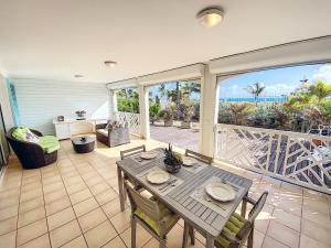 un patio con tavolo e sedie sul balcone. di Princess Coco, Beachfront, Pool, Orient Bay, ultra fast Wifi a Orient Bay