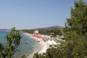 a beach with umbrellas and people in the water at House Ekton in Pefkari