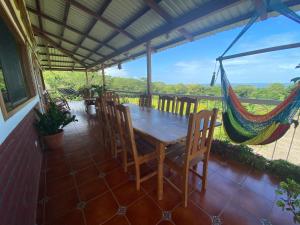 einen Tisch und Stühle auf einer Veranda mit Hängematte in der Unterkunft Finca Ometepe in Balgue