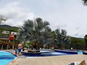 a man and a child standing by a swimming pool at Apartasol El Encanto in San Jerónimo