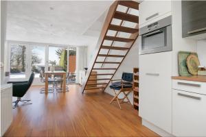 a kitchen and dining room with a spiral staircase at Lake House 19 relax accommodation in Warmond