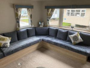 a large blue couch in a living room at Blackpool Static Caravan Marton Mere in Blackpool