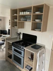 a kitchen with a stove and a counter top at Blackpool Static Caravan Marton Mere in Blackpool