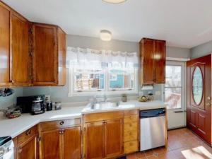 a kitchen with wooden cabinets and a sink and a window at The Blue Bungalow in Montrose