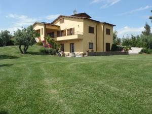 a house with a large lawn in front of it at Locanda Degli Etruschi in Montalto di Castro