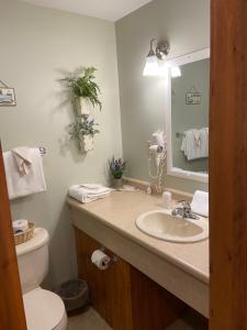 a bathroom with a sink and a toilet and a mirror at The Garrett Inn in Oakland