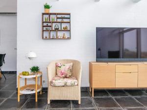 a living room with a tv and a chair and a table at 6 person holiday home in R m in Bolilmark