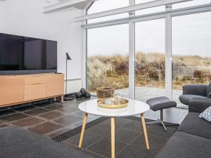 uma sala de estar com uma televisão e uma mesa em 6 person holiday home in R m em Bolilmark