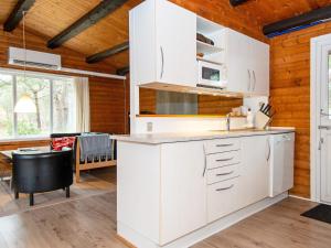 a kitchen with white cabinets and a dining room at Three-Bedroom Holiday home in Rømø 50 in Rømø Kirkeby