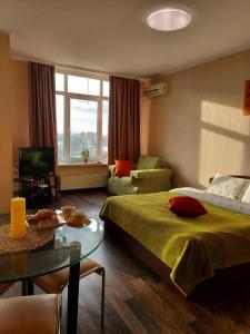 1 dormitorio con cama, mesa y sofá en Студія з неймовірним краєвидом біля м Лівобережна, en Kiev